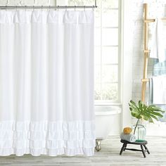 a white shower curtain next to a bath tub