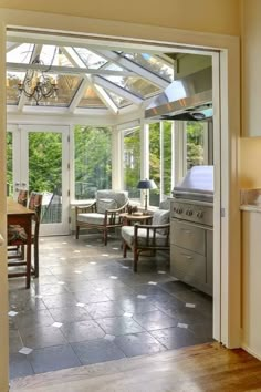 an open kitchen and dining room with glass doors that lead to the outside patio area