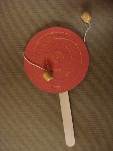 a red paper plate with gold thread on it and a wooden stick sticking out of it