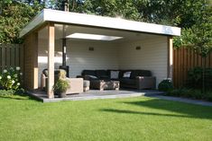 an outdoor living area with couches in the grass