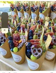 an assortment of fruits and vegetables in paper cups