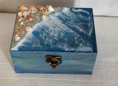 a blue box with seashells in it sitting on a table