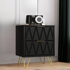 a black cabinet with gold legs and a camera on top