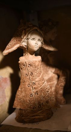 a clay sculpture of a woman wearing a hat