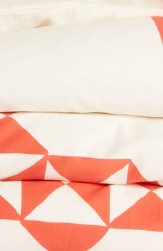 an orange and white bed spread on top of each other