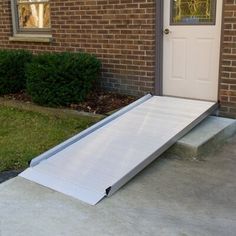 a metal ramp sitting in front of a door on the side of a brick building