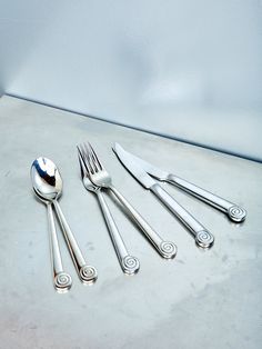 five forks and two spoons on a table