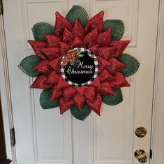 a red and green christmas wreath on the front door