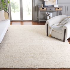 a living room with a white rug and chair