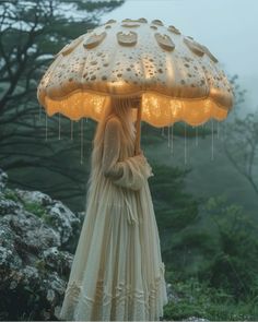 a woman in a dress holding an umbrella with raindrops hanging from it's sides