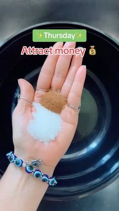 a person holding their hand out with some powder in it on top of a black plate