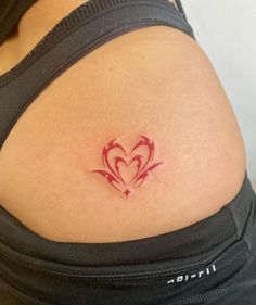 a woman's stomach with a red heart tattoo on her lower back and side