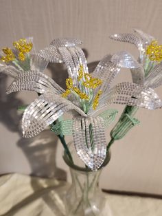 a glass vase filled with flowers on top of a white cloth covered tableclothed surface