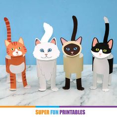 four paper cats standing next to each other on a marble surface with blue wall in the background