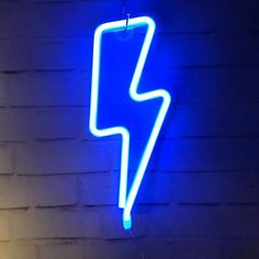 a blue neon sign hanging from the side of a brick wall