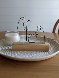 a wooden table with a white plate on it and a candle holder in the middle