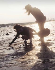 two people are playing in the water at the beach