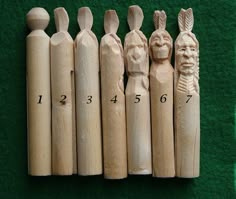 six wooden crochet hooks are lined up next to each other on a green surface