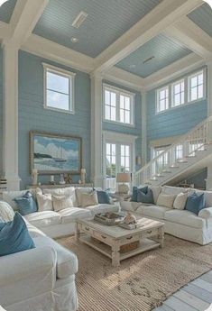 a living room filled with white furniture and blue walls