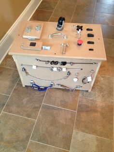 a drawer with various items on it sitting on the floor in front of a wall