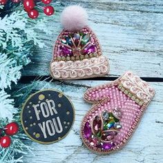 two christmas mittens are sitting next to a sign that says for you on it