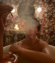 a man sitting in a bathtub with steam coming out of his head and hands