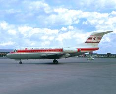 an airplane is sitting on the tarmac with clouds in the sky behind it,