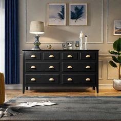 a black dresser with gold knobs in a living room