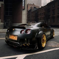 a black sports car parked on the side of the road in front of some buildings