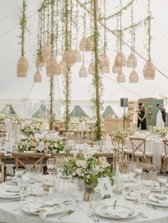 the tables are set with white linens and greenery for an outdoor wedding reception