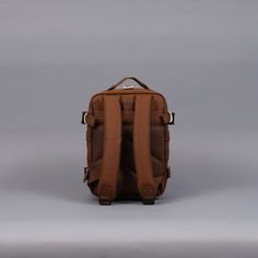 the back view of a brown backpack on a gray background