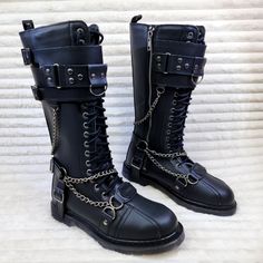 Bolt-415 By Demonia Vegan Leather 1 1/4" Heel Size: Men's 1.25" (32mm) Heel 18 Eyelet Unisex Knee High Combat Boot Featuring Featuring Studded Buckled Top Panel, Harness Strap, O-Ring, D-Ring , Hanging Chain Details And Branded Metal Plate @ Toe, Inside Zip Closure. Silver Punk Boots For Streetwear, Gothic Silver Boots With Round Toe, Silver Gothic Boots With Metal Feet, Gothic Silver Boots With Metal Feet, Silver Boots With Rivets And Round Toe, Silver Round Toe Boots With Rivets, Silver Leather Moto Boots With Round Toe, Shoes Demonia, Shoe References