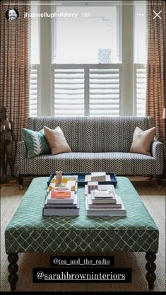 a living room with a couch, coffee table and window covered in blinds on the windowsill