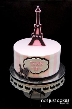 a pink and white cake with the eiffel tower on it's side