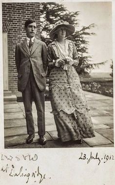 an old black and white photo of a man and woman standing next to each other