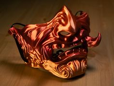 this menacing half-mask brings to life the terrifying visage of a Japanese oni in vivid detail. The mask is printed using a mesmerizing blend of shiny red and orange filament, creating an effect reminiscent of molten lava or blazing embers. This dynamic coloration ensures you'll stand out in any crowd, whether you're stalking a fantasy battlefield or commanding attention at a convention. Key Features: * Authentic Design: Covers the nose and mouth in traditional menpo style, featuring fearsome tu Fantasy Battlefield, Cyberpunk Techwear, Paper Mache Mask, Japanese Oni, Molten Lava, Oni Mask, Gold Mask, Japanese Folklore, Costume Masks