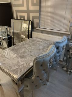 a marble dining table and chairs in a room with mirrored walls, flooring and windows