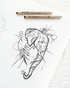 a drawing of an elephant with its trunk in the air and some pencils next to it