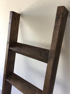 a wooden ladder leaning against a white wall