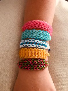 a person's arm with several bracelets on top of it, all in different colors