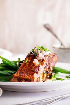 a white plate topped with meat and green beans