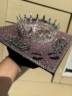 a woman's hand is holding a tiara