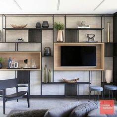 a living room filled with furniture and a flat screen tv mounted on a wall above it