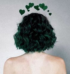 the back of a woman's head with green hair and hearts drawn on it