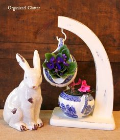 two ceramic rabbits are sitting next to each other with flowers in their pots on them