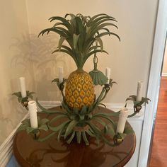 a pineapple is sitting on top of a table with candles in the center and around it