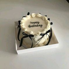 a birthday cake with the words happy birthday written on it in black and white icing