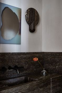 a bathroom with marble counter tops and a painting on the wall next to it's faucet