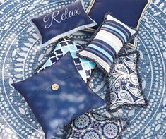 blue pillows on a round rug with the word relax written in cursive font