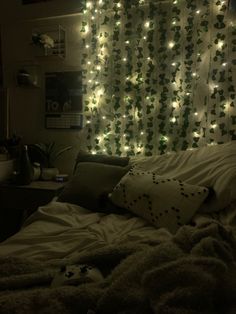 a bedroom with lights on the wall and a bed in front of a large window